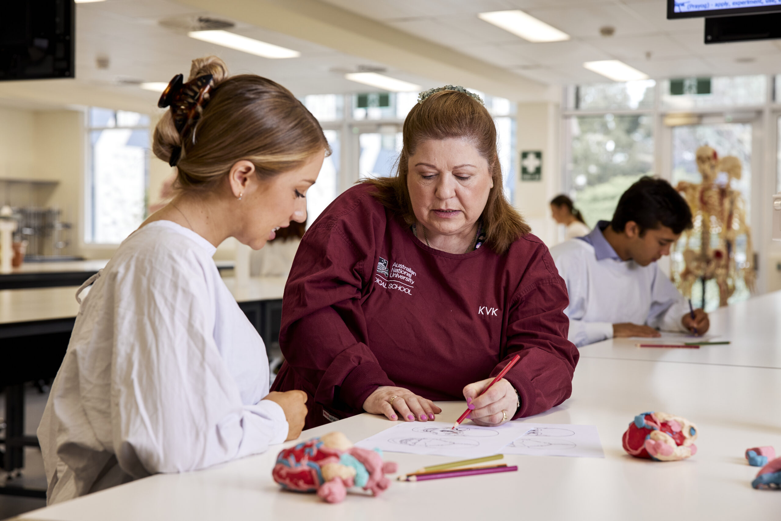 An academic and a student collaborate in a lab setting.